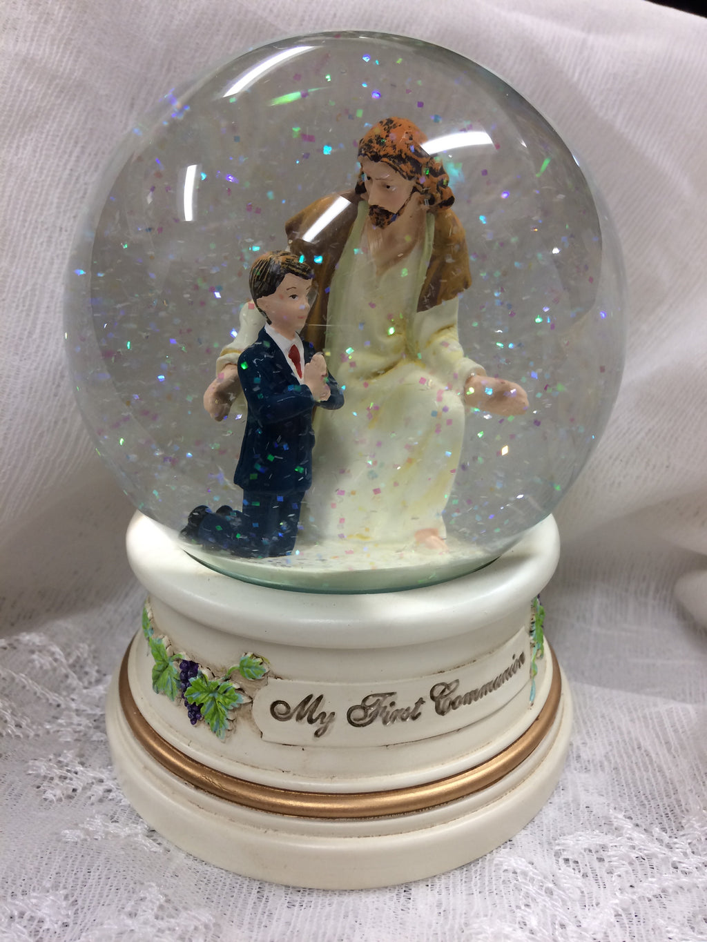 My First Communion glitter globe shows Jesus with a boy kneeling and praying.